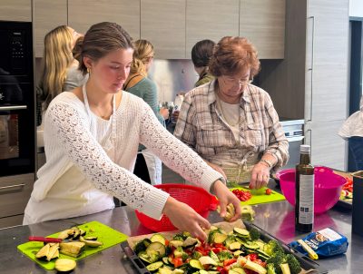 A Virginia Tech student and a senior prepare vegetables together in a kitchen in Riva San Vitale, Switzerland.